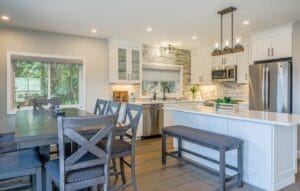 Remodeled kitchen with dining table and white isle - home additions salem nh